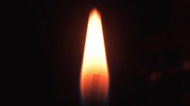 Fiamma liscia di una candela su sfondo nero. Luce da fiamma di candela — Video Stock