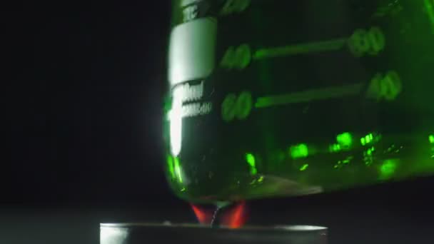 Pallone di vetro con liquido verde chimico è tenuto sopra fuoco . — Video Stock