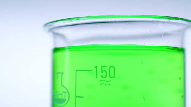 Forskare hand i en steril handske sätter en kemisk kolv med en grön — Stockvideo