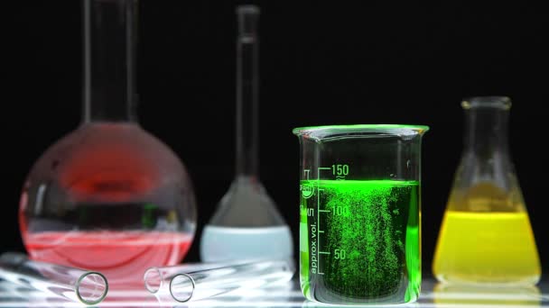 Cristalería química de laboratorio con líquidos en el interior sobre fondo negro — Vídeos de Stock