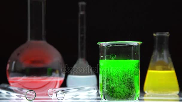 Vidrio en laboratorio químico lleno y líquido de color durante la reacción — Vídeos de Stock