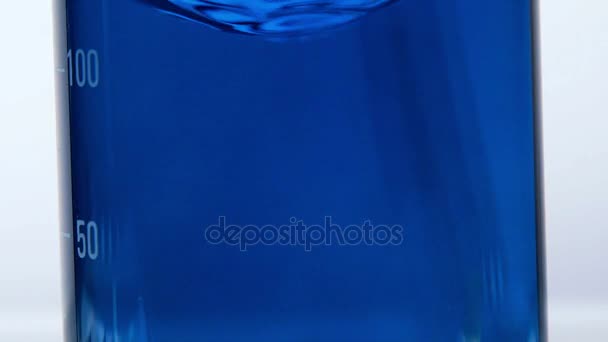 Dem Wasser wird blaues Reagenz zugesetzt. Färbung von klarer Flüssigkeit in Blau — Stockvideo