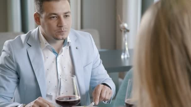 Kolacja w restauracji: człowiek zjada sałatkę, za pomocą noża i widelca — Wideo stockowe