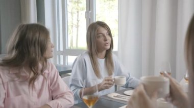 Arkadaş şirket bir araya geldi bir kafe ve sohbet, dedikodu, gülmek.