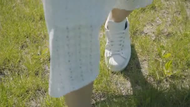 Summer walk, easy gait. The girl gently steps on the grass. — Stock Video