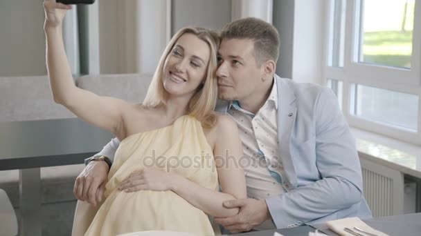 A pregnant woman and her husband in a light suit are photographed — Stock Video