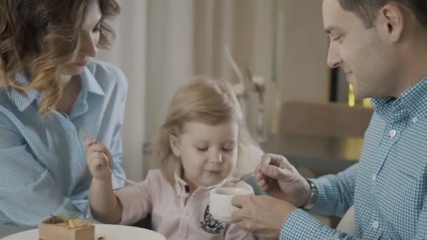 Familie van drie personen heeft ontbijt in mooie en gezellige restaurant — Stockvideo