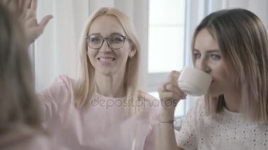 İki genç kadın bir kafede oturmak ve onların arkadaşlarıyla iletişim kurmak.