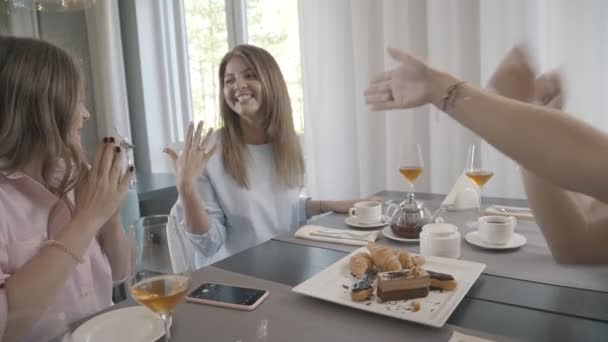 Щаслива дівчина запросила своїх друзів до кафе, щоб поговорити про заручини — стокове відео