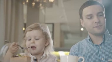 Bebek Cafe. Küçük tatlı kız kendini veliler ile masada yiyor.