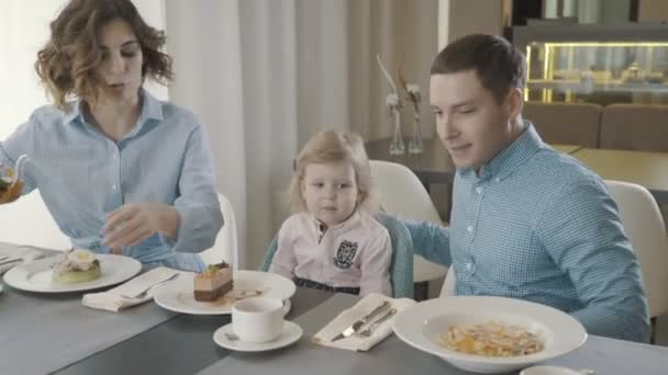 Μια οικογένεια με ένα μικρό παιδί σε ένα εστιατόριο: ο μπαμπάς, μαμά και κόρη — Αρχείο Βίντεο