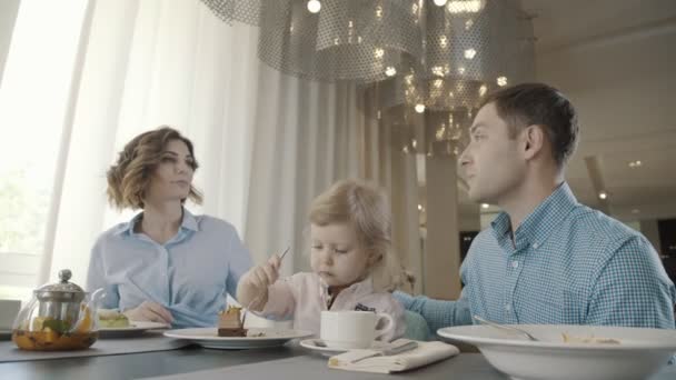 Ouders zijn geraakt door hun dochter, die probeert om te eten zelf. — Stockvideo