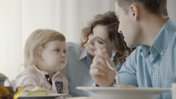 Pais elegantes com uma criança estão tomando café da manhã no restaurante . — Vídeo de Stock