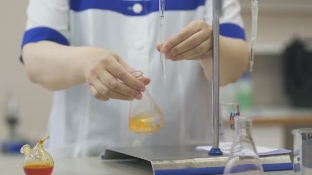 Chemik drží baněk a kádinky v rukou, provádí výzkum. — Stock video