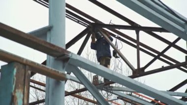 İnşaat çalışmaları: bina metal çerçeve. İş yerinde Kaynakçı.