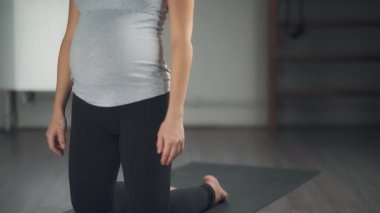 Güzel bir hamile kadın bir yoga stüdyosunda uzanır.