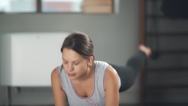 Terhes nő nem jóga, ő húzza a kéz és a másik lábát. — Stock videók