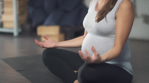 Egy terhes nő ül a lótusz helyzet: közeli, a kéz. — Stock videók