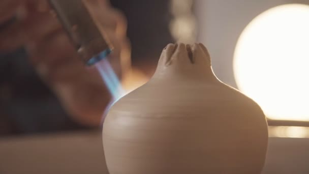 Potter hace un disparo de una figura de una granada, utilizando un soplete — Vídeos de Stock