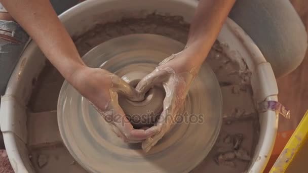 Handen in de klei touch zorgvuldig en voorzichtig de figuur op potters wiel — Stockvideo