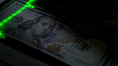 Doğrulama için bir nakit notu inceden inceye gözden geçirmek. Yakın çekim. Yeşil ışın yavaş hareket