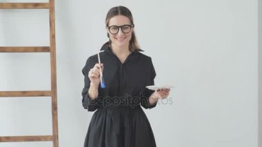 Keskin şekil çizim ve bir palet için bir fırça tutan kadınla