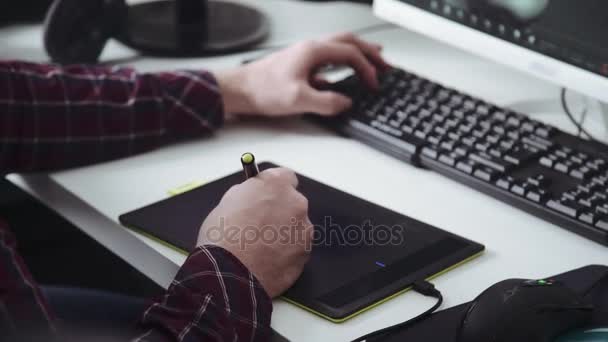 Tablet gráfico: o designer trabalha com um tablet e um computador — Vídeo de Stock