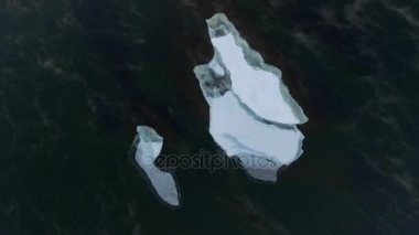 Buz yüzer açık denizde bir quadrocopter sürükleniyor. Beyaz buz parçası