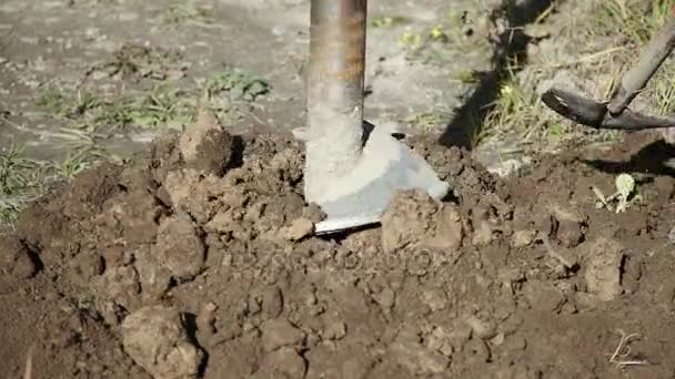 Een grote industriële boor schroef treedt geleidelijk aan de grond — Stockvideo