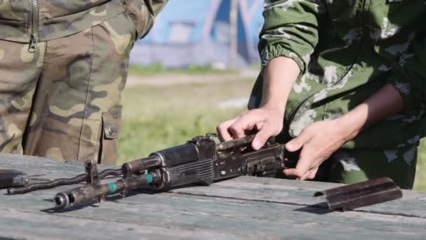 Cadete em uniformes de camuflagem recolhe desmonta o AK-47. Fechar — Vídeo de Stock