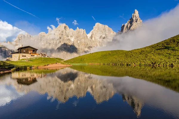 Arka plan üzerinde bir Alp dağ evi ile su yansıması Pale di San Martino tepeler (İtalyan Dolomites). — Stok fotoğraf