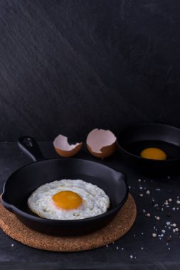 siyah pan ve madde koyu arka plan üzerinde sahanda yumurta