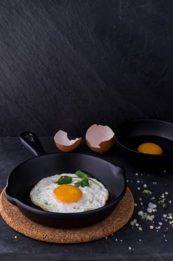 siyah pan ve madde koyu arka plan üzerinde sahanda yumurta