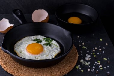 siyah pan ve madde koyu arka plan üzerinde sahanda yumurta
