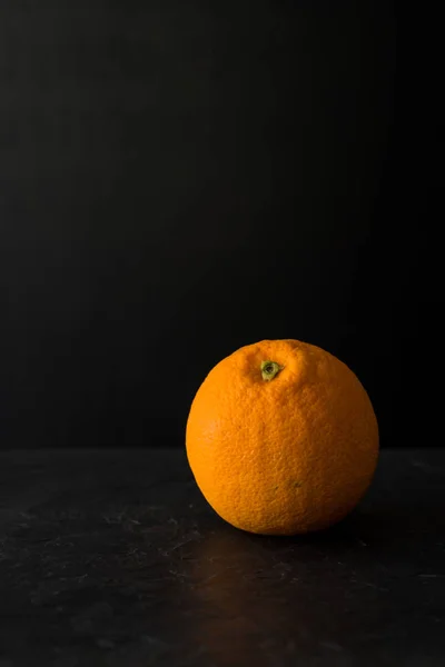 Orange on slate stone with dark background — Stock Photo, Image