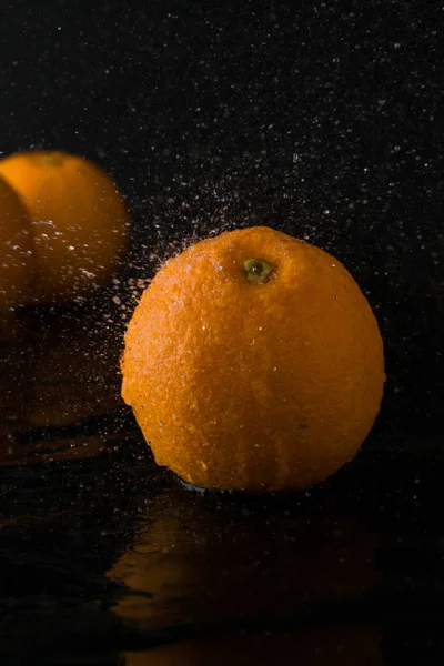 turuncu koyu arka plan ile kayrak taş. portakal su sıçrama. taze meyve kavramı