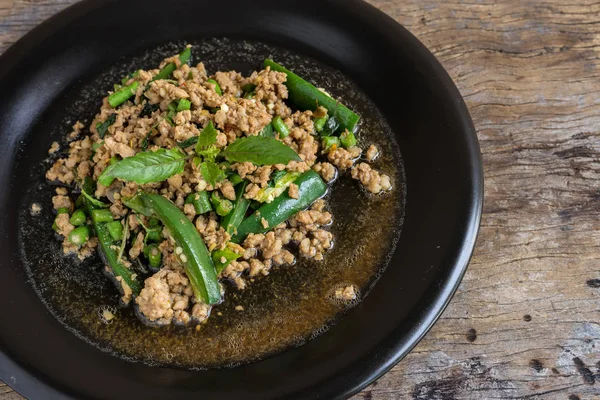 Fesleğenli kızarmış kıyılmış domuz siyah tabak içinde karıştırın. Tayland popüler sokak gıda