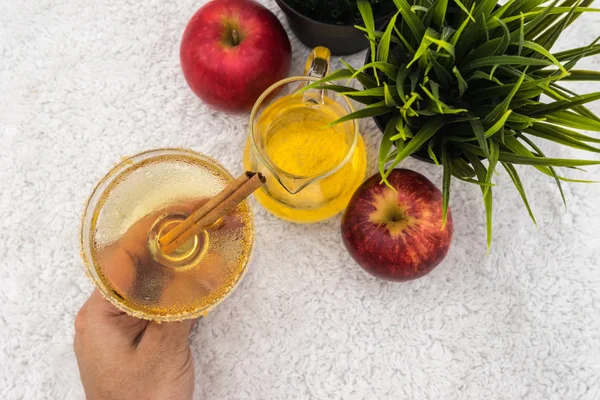 soğuk elma suyu ve tarçın cam. cam tutan el