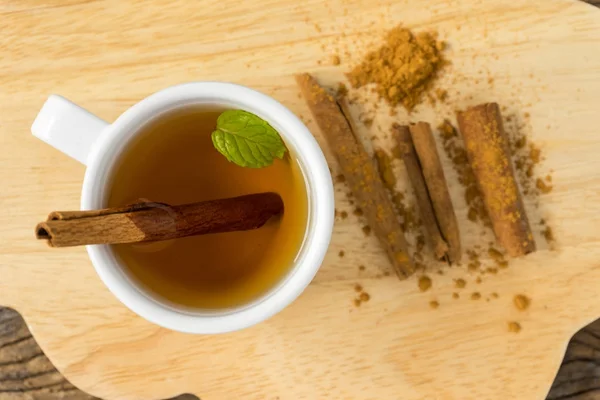 tarçın ve eski ahşap üzerine tarçın zemin ile fincan sıcak elma suyu. sonbahar gıda kavramı