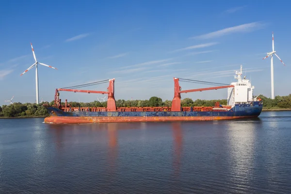 Frakt fartyg på en flod mellan två vindkraftverk — Stockfoto