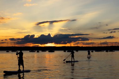 Gün batımında, Gölü Starnberg, Bavyera, üç stand-up paddler
