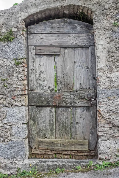 石の古い木製のドアは壁を建てた — ストック写真