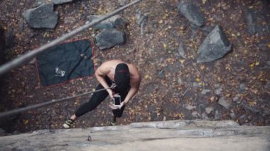 Güçlü üstsüz dağcı fotoğraf selfie kayanın üzerinde yapar.