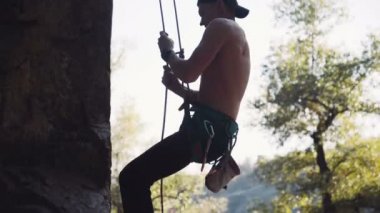 Üstsüz dağcı Cliff üzerinde azalan
