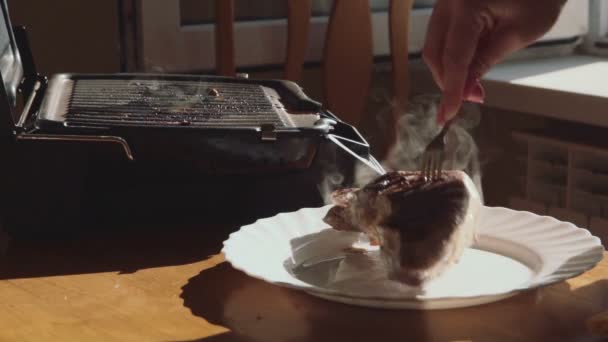 Повар кладет хорошо приготовленный стейк на тарелку — стоковое видео