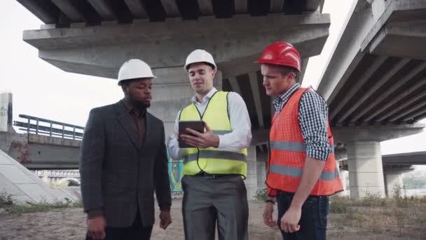 Tres arquitectos discutiendo proyecto usando tableta — Vídeos de Stock