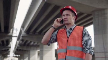 Genç bir işçi cep telefonu üzerinde konuşurken
