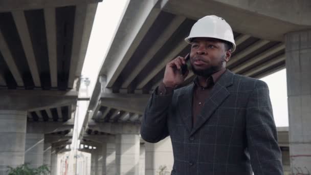 Homme souriant en casque blanc au téléphone — Video