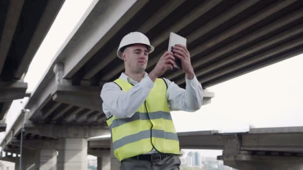 Inżynier na zewnątrz przy użyciu komputera typu tablet — Wideo stockowe