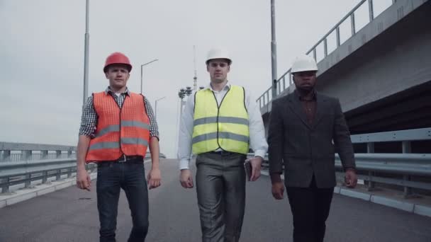 Ingenieros de construcción caminando en rampa de carretera — Vídeos de Stock